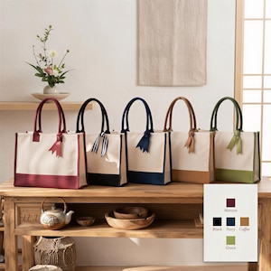 a row of five colorful handbags on a wooden shelf, with a vase of flowers and a teapot nearby.