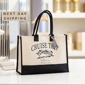A beige tote bag with the text "CRUISE TRIP" printed on it, along with a graphic of a cruise ship. The bag is placed on a white surface, and there is a sign that says "NEXT DAY SHIPPING" in the background.