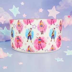 May include: A cylindrical container with a repeating pattern of cartoon figures in various poses, set against pink and blue circular backgrounds. The figures are dressed in colorful outfits. The background is a light blue with star shapes.
