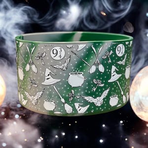 May include: A green and white cylindrical container with a repeating pattern of wizarding symbols, including brooms, hats, and the number 9 3/4. The container has a gradient effect, transitioning from white to green.