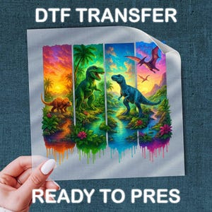 May include: A DTF transfer sheet featuring a vibrant, multi-panel graphic of dinosaurs in a prehistoric landscape. The design includes a T-Rex, a triceratops, and a pterodactyl amidst tropical foliage, rivers, and a sunset, with text reading DTF TRANSFER READY TO PRES.