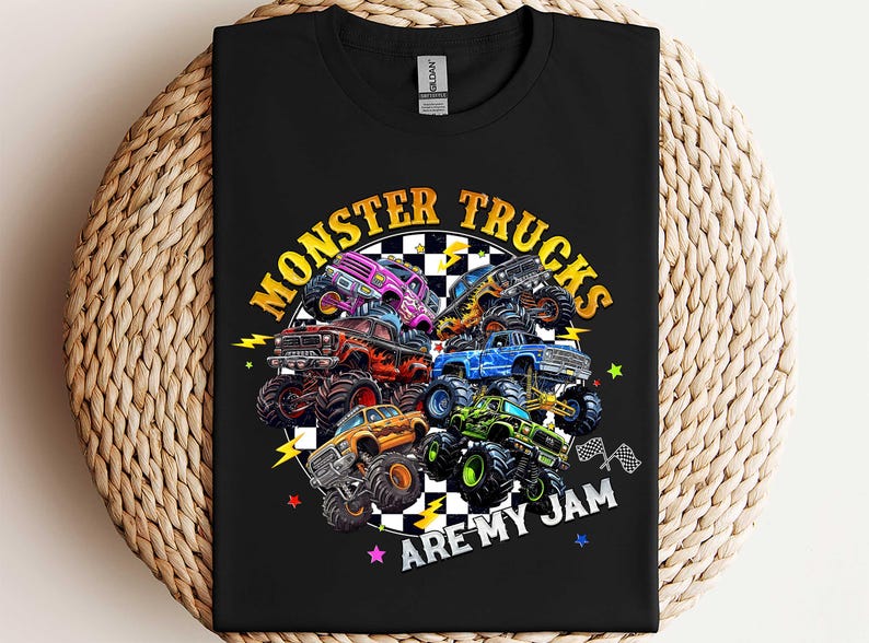 A black t-shirt with a graphic design featuring various monster trucks and the text "MONSTER TRUCKS ARE MY JAM" printed on it.
