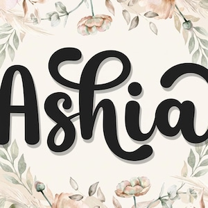 May include: A black script font displays the name Ashia in the center of the image. The text is surrounded by a circular border composed of watercolor-style illustrations of soft pink flowers, green leaves, and beige pampas grass elements.