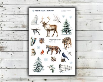 Könnte beinhalten: Ein Stickerbogen mit dem Titel ATLAS DESIGN STUDIO Woodland Study II D-X-025 mit Aquarellillustrationen von einem weißen Fuchs, Rentier, Wolf, Luchs, Eichhörnchen, Kardinal, Specht, Meise, Tannenbäumen, Schneeflocken, Zweigen, Zapfen und einem Holzzaun.