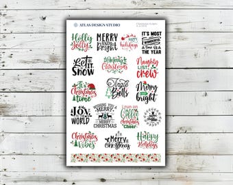 Könnte beinhalten: Ein rechteckiger Aufkleberbogen mit verschiedenen weihnachtlichen Schriftzügen in roter, grüner und schwarzer Typografie. Die Designs enthalten Texte wie Holly Jolly, Merry and Bright, Let It Snow und Joy to the World sowie eine florale Bordüre am unteren Rand.