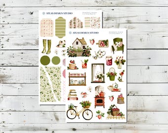 Könnte beinhalten: Zwei Bögen dekorativer Aufkleber mit Erdbeermotiv. Die Aufkleber zeigen Illustrationen eines Hauses, eines Fahrrads, Erdbeeren, Teesets und anderer Elemente zum Thema Garten. Der Text "ATLAS DESIGN STUDIO" ist auf den Bögen zu sehen.