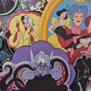 May include: A collection of colorful, layered paper cutouts featuring Disney villains and characters. Includes Ursula, Cruella de Vil, Captain Hook, and Cinderella's stepmother. The cutouts have a glittery, iridescent background.