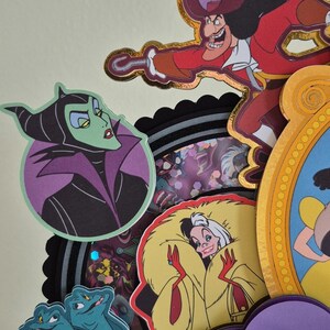 May include: A collection of colorful, die-cut character images, including Captain Hook, Maleficent, Cruella de Vil, and Ursula. The images are layered and feature gold foil accents, with a variety of shapes and sizes. The overall theme is Disney villains.