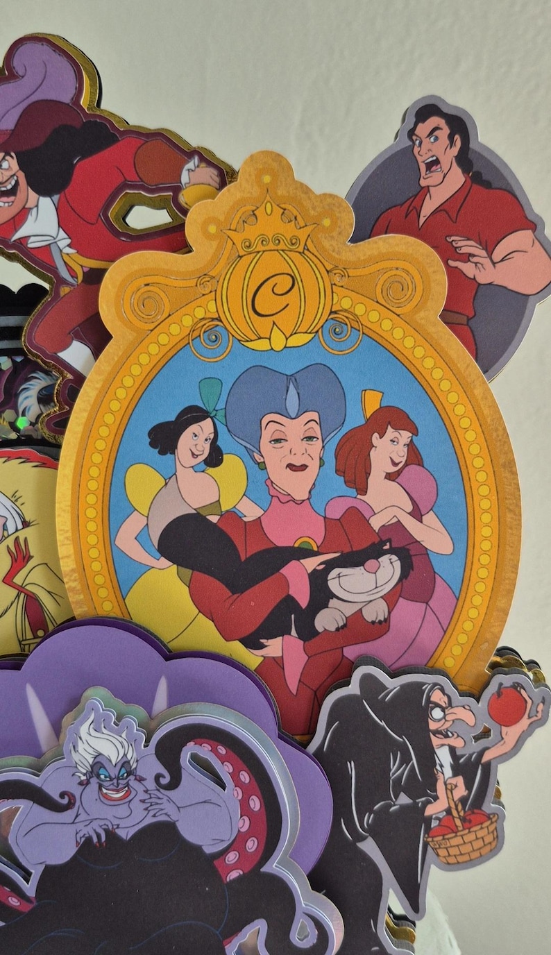 May include: A collection of colorful cartoon character cutouts, including villains and princesses. The central image features a portrait of Cinderella's stepmother and stepsisters. Other characters include Ursula, Captain Hook, and Gaston.