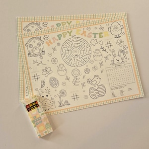May include: Easter-themed coloring placemats with a maze, word search, and various Easter-related illustrations. A small box of crayons is included. The placemats feature the text "HAPPY EASTER" and are designed for children.