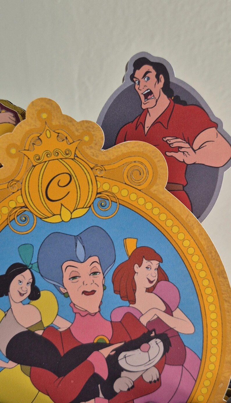 May include: Colorful die-cut character cutouts from the animated film Cinderella. Includes images of Cinderella, the stepmother, and Gaston. The characters are set against a light background.