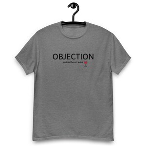 May include: A heather gray t-shirt with the text "OBJECTION" above "unless there's wine" and a wine glass graphic. The shirt is hanging on a black hanger.