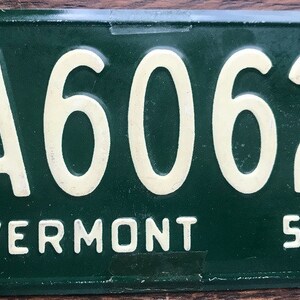 May include: Green Vermont license plate with white lettering. The plate number is A6062 and the year is 53.