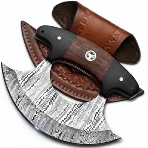 Op de afbeelding: Damascus stalen mes met een gebogen lemmet en een donkerhouten handvat. Het handvat is geaccentueerd met zwart en een klein zilveren embleem. Een bruine leren schede is inbegrepen.