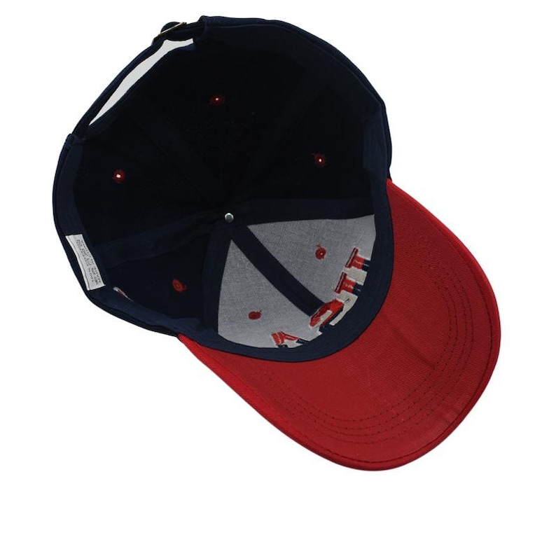 May include: A navy blue baseball cap with a red brim. The interior features the embroidered letters "ITT" in red, white, and blue. The cap has a metal clasp for adjustment and a white tag.