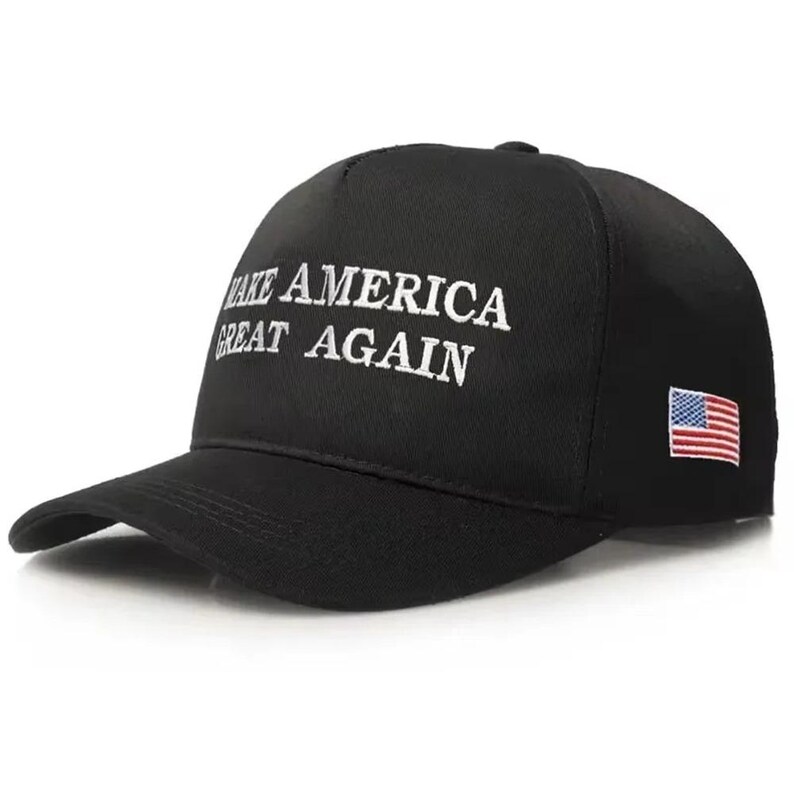 Puede incluir: Gorra de b&eacute;isbol negra con el texto blanco "MAKE AMERICA GREAT AGAIN". La gorra tiene una visera curva y un peque&ntilde;o parche de la bandera estadounidense en el lateral.
