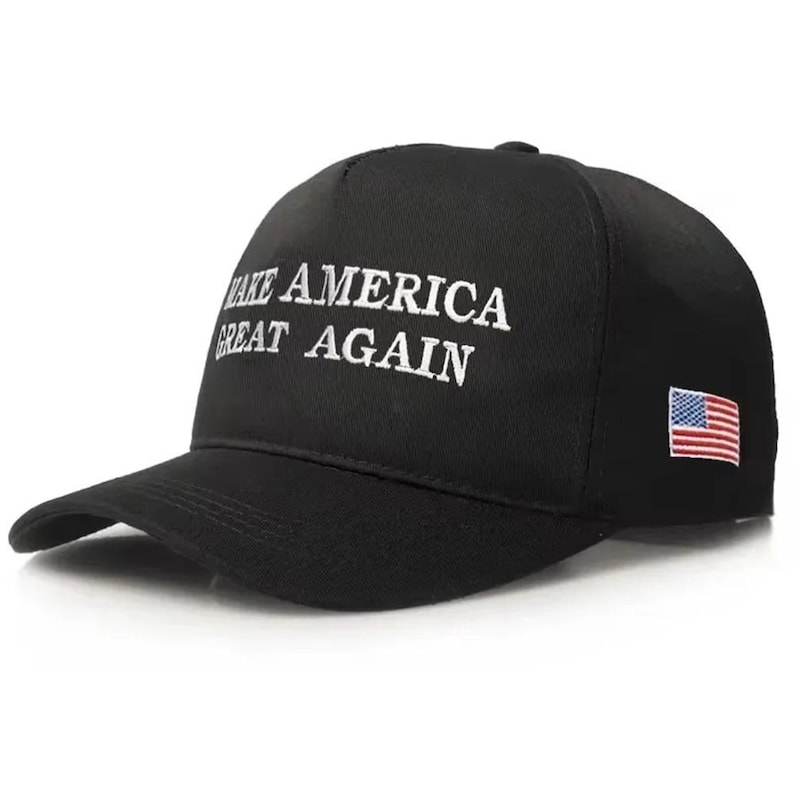 Puede incluir: Gorra de b&eacute;isbol negra con el texto blanco "MAKE AMERICA GREAT AGAIN". La gorra tiene una visera curva y un peque&ntilde;o parche de la bandera estadounidense en el lateral.