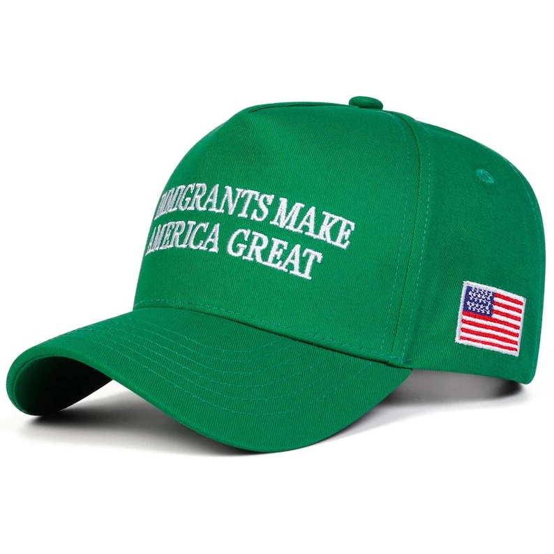 Puede incluir: Gorra de b&eacute;isbol verde con la frase bordada en blanco "IMMIGRANTS MAKE AMERICA GREAT". La gorra presenta un peque&ntilde;o parche de la bandera estadounidense en el lateral.