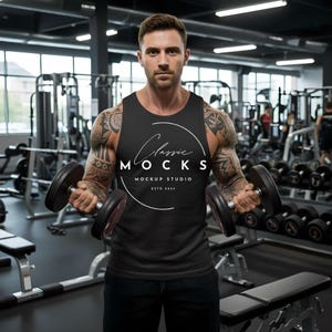 May include: Black tank top with the text "Classic Mocks Mockup Studio ESTD 2021" in a white circular design. The person in the image is holding two dumbbells in a gym setting.