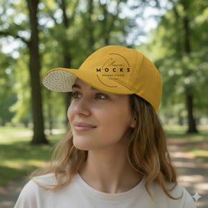 Puede incluir: Gorra de béisbol de color amarillo mostaza con visera curva. La parte inferior de la visera es de tela blanca con pequeños lunares negros. La gorra lleva el texto "Classic Mocks Mockup Studio" en un diseño circular.