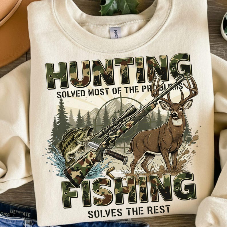 May include: Cream-colored sweatshirt with a hunting and fishing graphic. The design includes a rifle, a deer, a fish, and the text "HUNTING SOLVED MOST OF THE PROBLEMS FISHING SOLVES THE REST."