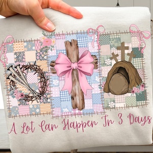 Puede incluir: Una tela de color claro con un diseño de patchwork que presenta símbolos religiosos. El diseño incluye una cruz de madera con un lazo rosa, una corona de espinas, clavos y una tumba vacía. El texto "A Lot Can Happen In 3 Days" está escrito en rosa.