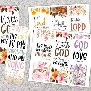 May include: A collection of floral-themed bookmarks and decorative cards. The bookmarks and cards feature inspirational quotes and Bible verses in various fonts and colors, with floral accents in shades of pink, orange, and purple.