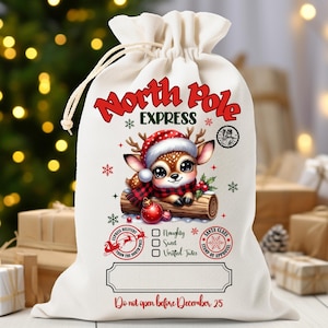 May include: A white drawstring Christmas gift bag with a cute cartoon deer wearing a Santa hat and scarf. The bag reads "North Pole Express" and "Do not open before December 25."