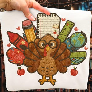 May include: White fabric with an embroidered design featuring a turkey wearing glasses, surrounded by school supplies like a pencil, notebook, ruler, and globe. Red hearts and apples are also included in the design.