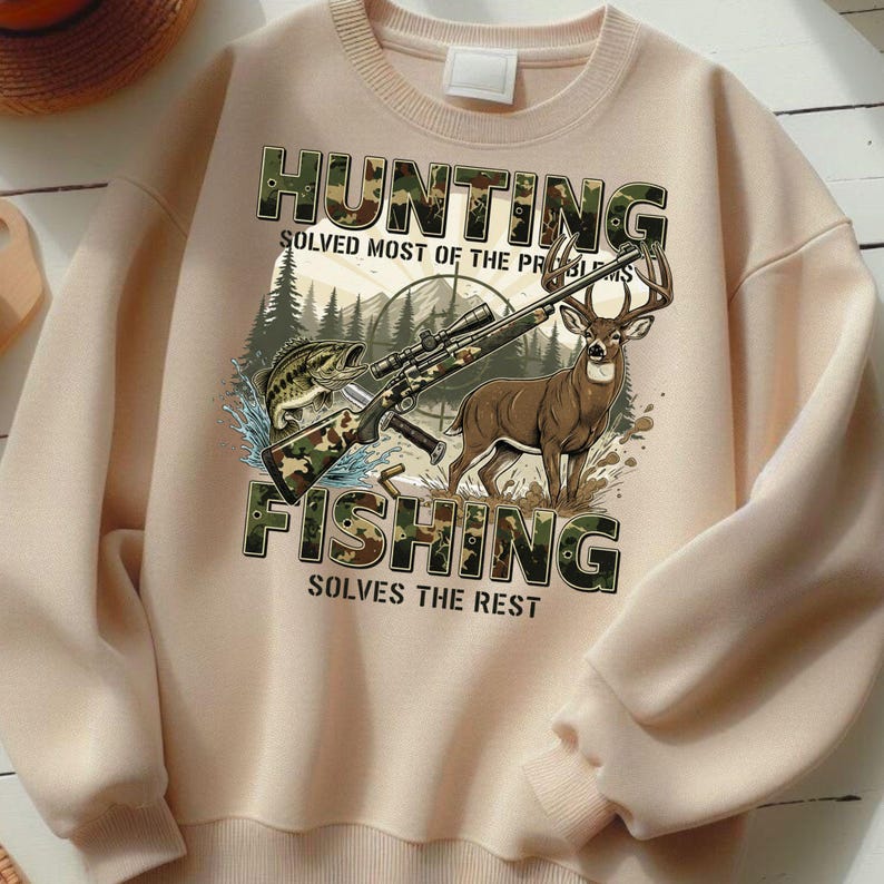 May include: A beige sweatshirt with a graphic featuring a rifle, a fish, and a deer. The words "HUNTING" and "FISHING" are printed in camouflage-style letters, with the phrases "SOLVED MOST OF THE PROBLEMS" and "SOLVES THE REST" below.