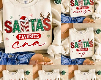 Könnte beinhalten: Cremefarbene Sweatshirts mit dem Text "SANTA'S FAVORITE" in Rot und Grün, mit verschiedenen Berufen darunter. Die Sweatshirts zeigen einen Weihnachtsmannhut und Rentiergeweihe. Die Texte "CNA", "nurse", "RN", "NP" und "CPR" sind ebenfalls sichtbar.