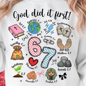 May include: White sweatshirt with a colorful graphic design. The design includes the text "God did it first!" along with various religious symbols, numbers, and Bible verses. The graphic features a pink book, a globe, and a money bag.