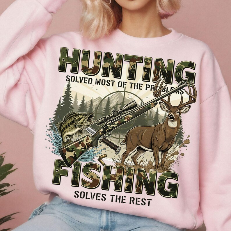 May include: Pink sweatshirt with a graphic featuring a rifle, deer, and fish, with the text "HUNTING SOLVED MOST OF THE PROBLEMS FISHING SOLVES THE REST". The design includes a forest and sun.