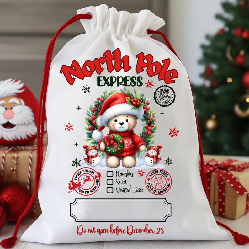 May include: White drawstring Christmas gift bag with red accents. The bag features a teddy bear wearing a Santa hat and sweater, surrounded by a wreath. Text includes "North Pole Express" and "Do not open before December 25."