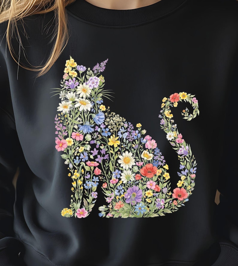 May include: Black sweatshirt featuring a floral cat design. The cat silhouette is filled with a variety of colorful flowers, including daisies, poppies, and lavender. The flowers are in shades of pink, yellow, blue, and purple, creating a vibrant and eye-catching design.