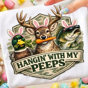 May include: White t-shirt featuring a graphic of a duck, deer, and fish wearing bunny ears and sunglasses. The deer holds a carrot. The text "HANGIN' WITH MY PEEPS" is displayed on a banner.