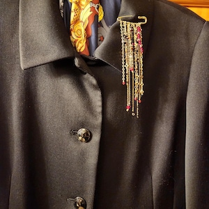 Broszka z 18-karatowego złota z wielowarstwowymi łańcuszkami i czerwonymi kryształami