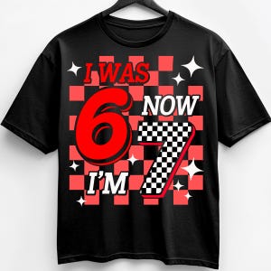 Puede incluir: Camiseta negra con un dise&ntilde;o a cuadros rojos y negros. La camiseta presenta el texto "I WAS 6 NOW I'M 7" en rojo y blanco. Gr&aacute;ficos de estrellas blancas est&aacute;n dispersos.