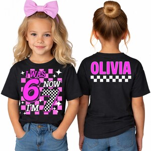 May include: Black t-shirt with a pink and checkered design. I Was 6 Now I'm 7 Girls Birthday Shirt | Matching Family Tees | Funny 7th Turning Seven Meme