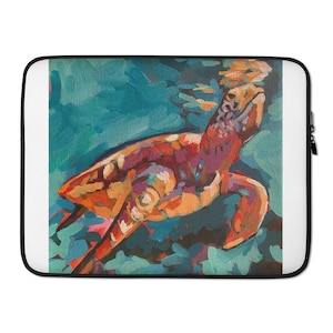 May include: A laptop sleeve with a colourful painting of a sea turtle. The artwork depicts the turtle in shades of orange, red, and purple against a teal background. The sleeve has a black border and a white interior.