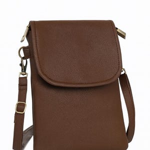 May include: A brown crossbody bag with a flap closure. The bag has a textured surface, a long adjustable strap, and gold-colored hardware. The bag is designed to be worn over the shoulder or across the body.