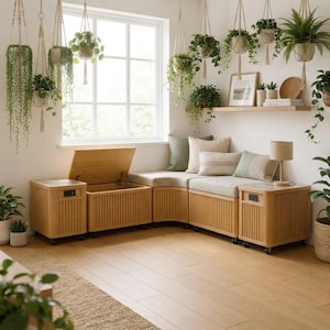 May include: A modular light wood storage bench set with a hinged lid, vertical slat detailing, and small wheels. The unit features light-coloured cushions, a corner configuration, and integrated side tables with built-in electrical outlets.