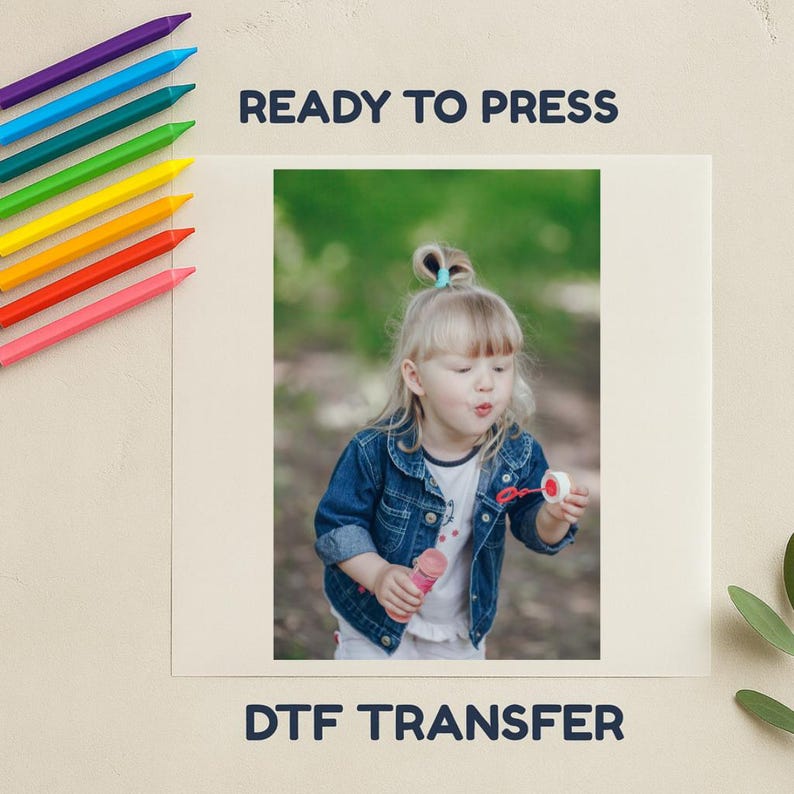 May include: A DTF transfer with the text "READY TO PRESS" and "DTF TRANSFER". The image shows a young child blowing bubbles. A set of rainbow-coloured crayons are on the left side of the image.