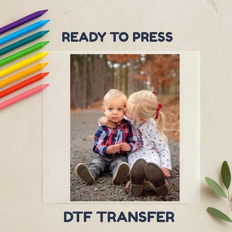 May include: A DTF transfer with a photograph of two children, one kissing the other. The image is framed by the text "READY TO PRESS" and "DTF TRANSFER". Colour pencils are in the upper left corner.