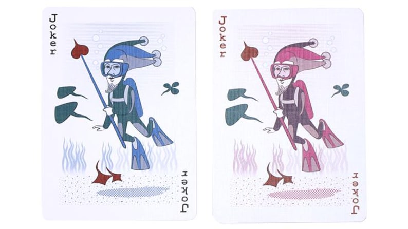May include: Two playing cards featuring the Joker. One card has a blue and teal diver, the other a pink and purple diver. Both divers are holding a spear with a heart-shaped tip. The word "Joker" is printed on each card.