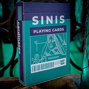 May include: A teal and navy blue deck of "SINIS PLAYING CARDS" with a white illustration of a queen. The box has the word "cardinates" printed vertically on the side and a barcode at the bottom.