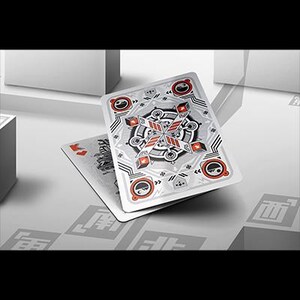 Puede incluir: Cartas de juego con un dise&ntilde;o geom&eacute;trico plateado y rojo en el reverso. Las cartas se muestran sobre una superficie blanca, con una est&eacute;tica minimalista. El dise&ntilde;o incluye elementos circulares y angulares.