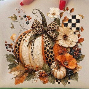 May include: A decorative pumpkin design with a leopard print bow, surrounded by fall foliage, flowers, and berries. The pumpkin has white and orange sections. The design includes a small pumpkin and a black and white checkered element.