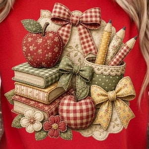 May include: A red sweatshirt featuring a layered fabric applique design of three stacked books, two apples, three pencils in a holder, and four decorative bows. The elements are crafted from various patterned fabrics including gingham, floral, and polka dot prints.