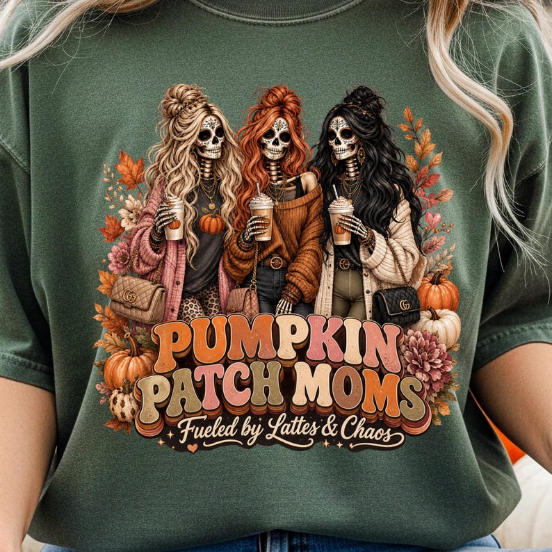 May include: Green t-shirt featuring a graphic of three skeleton women with long hair, holding coffee cups, and wearing fall-themed outfits. The text "PUMPKIN PATCH MOMS" and "Fueled by Lattes & Chaos" are also displayed.